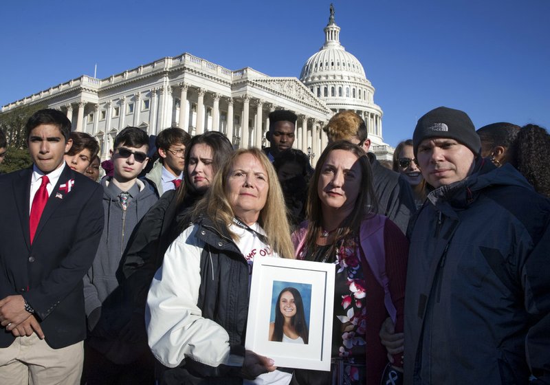 Terri Robinowitz, center, holds a framed photo of her granddaughter Alyssa Alhadeff who was killed in the shootings at Marjory Stoneman Douglas High School, with Alyssa's parents, Lori Alhadeff and Ilan Alhadeff, right, as lawmakers and gun control activists gather at the U.S. Capitol in Washington on Friday, March 23, 2018, a day before the March for Our Lives rally Saturday. 