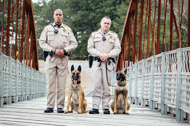 Faulkner County Sheriff’s Office patrol deputies Keenan Wallace, left, handler for canine officer Timon, and Adam Cox, handler for Terry, are pictured on the Springfield-Des Arc Bridge in Beaverfork Park in Conway. The dogs are the latest addition to the Sheriff’s Office, which hasn’t had a K-9 unit in several years. “We are beyond excited about this,” said Adam Bledsoe, public information officer for the Sheriff’s Office.