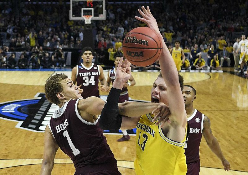Michigan forward Moritz Wagner (right) is fouled by Texas A&M forward DJ Hogg as he tries to take a shot Thursday during the Wolverines’ 99-72 victory over the Aggies in the West Region semifi nals of the men’s NCAA Tournament at Staples Center in Los Angeles.