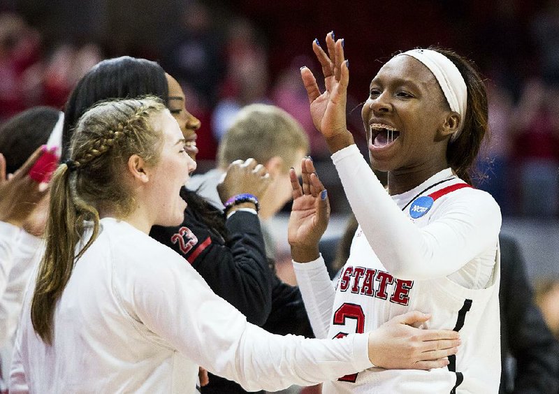 North Carolina State’s Kaila Ealey (right) greets teammates as she leaves the court in the final moments of Sunday’s women’s NCAA Tournament second-round game against Maryland in Raleigh, N.C. North Carolina State defeated Maryland 74-60 to advance to a Sweet 16 game at 6 tonight against Mississippi State.