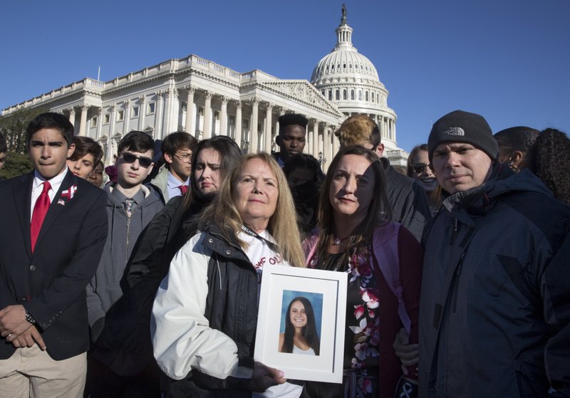 Terri Robinowitz, center, holds a framed photo of her granddaughter Alyssa Alhadeff who was killed in the shootings at Marjory Stoneman Douglas High School, with Alyssa's parents, Lori Alhadeff and Ilan Alhadeff, right, as lawmakers and gun control activists gather at the U.S. Capitol in Washington, Friday, March 23, 2018, a day before the March for Our Lives rally Saturday. 