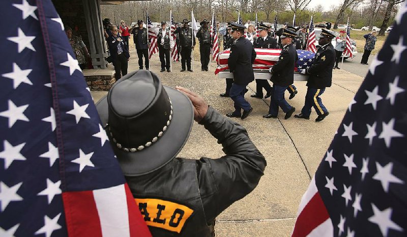 Members of the Army Honor Guard from Camp Robinson carry the remains of Pvt. Rudolph Johnson past members of the Patriot  Guard Riders motorcycle group during Friday’s service at the Arkansas State Veterans Cemetery in North Little Rock.