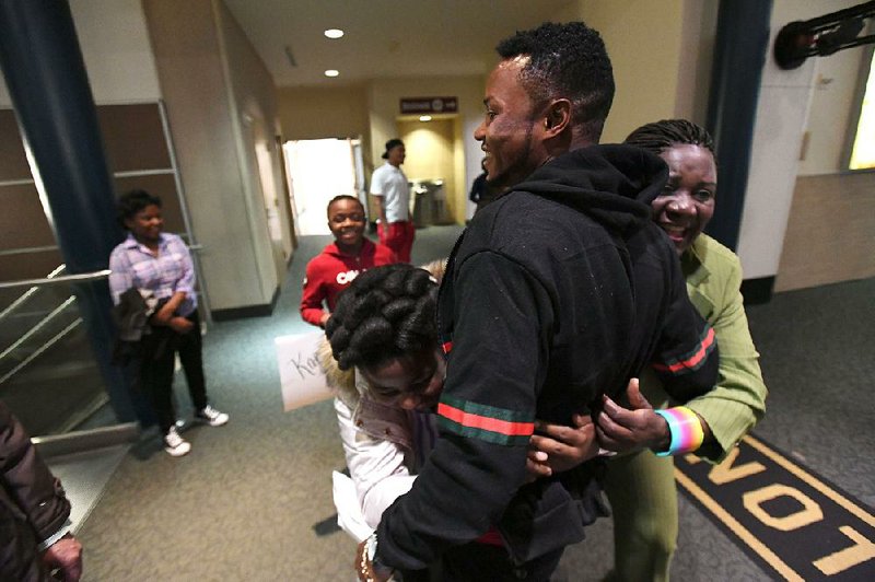 John Feruzi receives hugs from aunt Nyasa Safi and cousin Josephina Richard on Tuesday after arriving at the Northwest Arkansas Regional Airport in Highfill.
