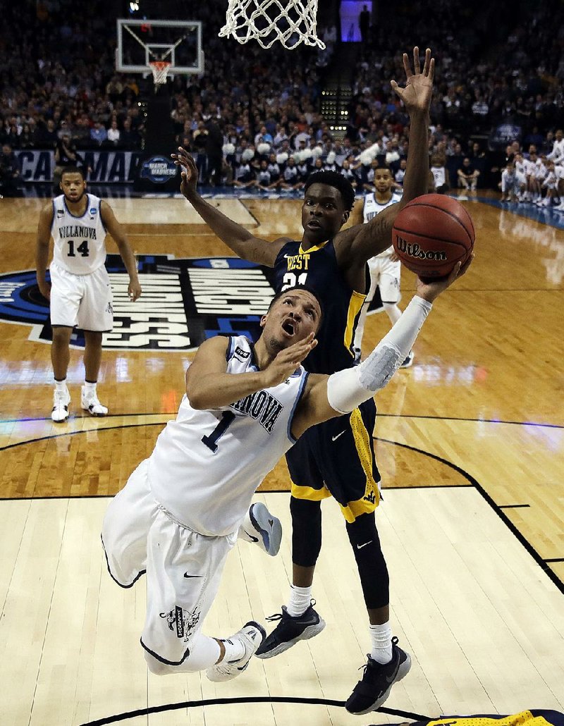 Villanova’s Jalen Brunson (1) drives past West Virginia’s Wesley Harris during the first half of the East Regional semifinals in the NCAA Tournament at the TD Garden in Boston. The Wildcats won 90-78 to advance to Sunday’s regional final.