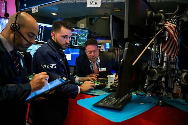 Traders work Friday on the floor of the New York Stock Exchange, where investors’ worries over trade tensions led to another day of widespread losses.