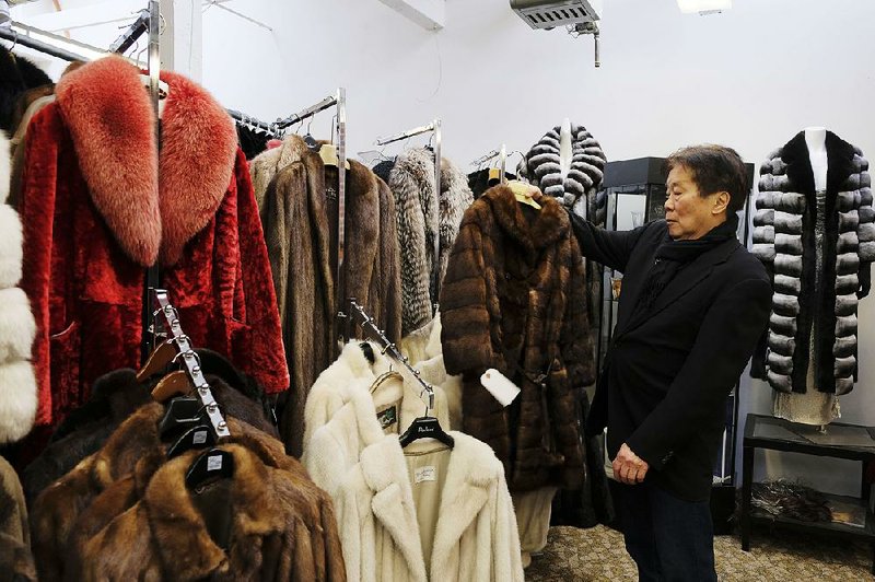 Benjamin Lin holds up a fur coat at the B.B. Hawk showroom in San Francisco.