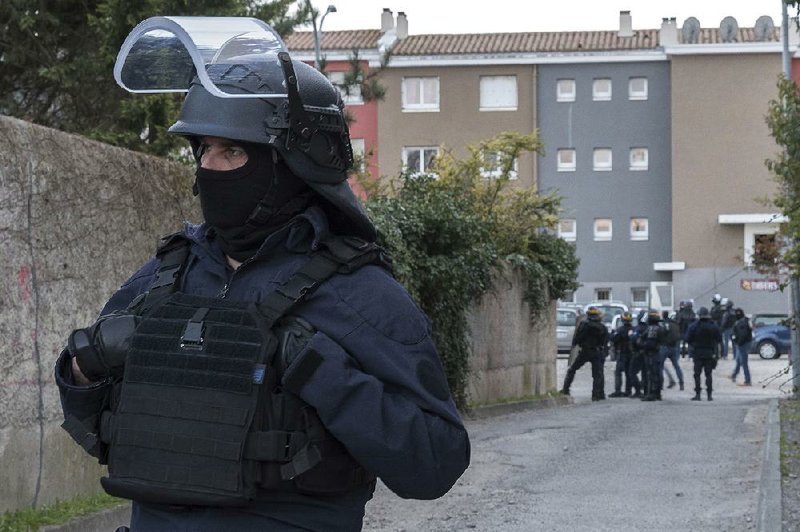 Police cordon off the area of a raid Friday in Carcassonne, France, at the home of the extremist who killed three people as he hijacked a car, opened fire on police and took hostages in a supermarket.