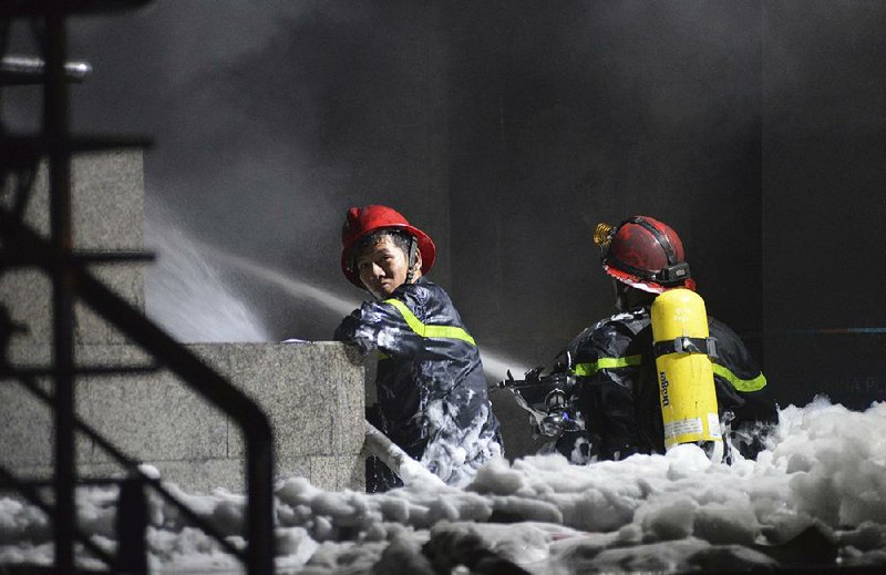 Firefighters work to extinguish a fire Friday at a condominium complex in Ho Chi Minh City, Vietnam.