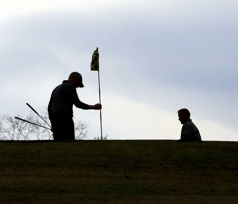FILE - A pair of golfers prepare to putt on the 16th green at War Memorial Golf Course Little Rock in this March 2018 file photo.
