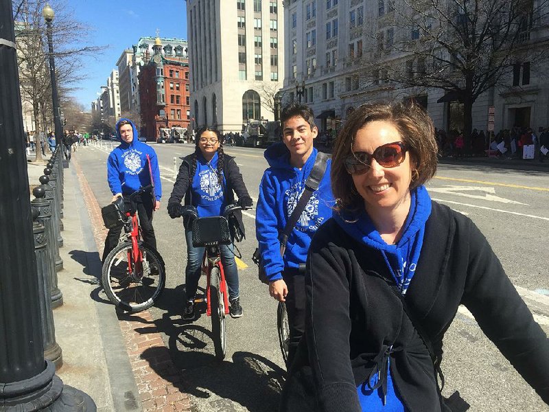 Sebastian Jennings (from left), Elizabeth Gonzalez, Johnny Rose and Allison Montiel ride bicycles toward Pennsylvania Avenue on Saturday in Washington for the anti-gun-violence march. Jennings, Gonzalez and Rose are students at Future School in Fort Smith, and Montiel is an adjunct faculty member at the school.