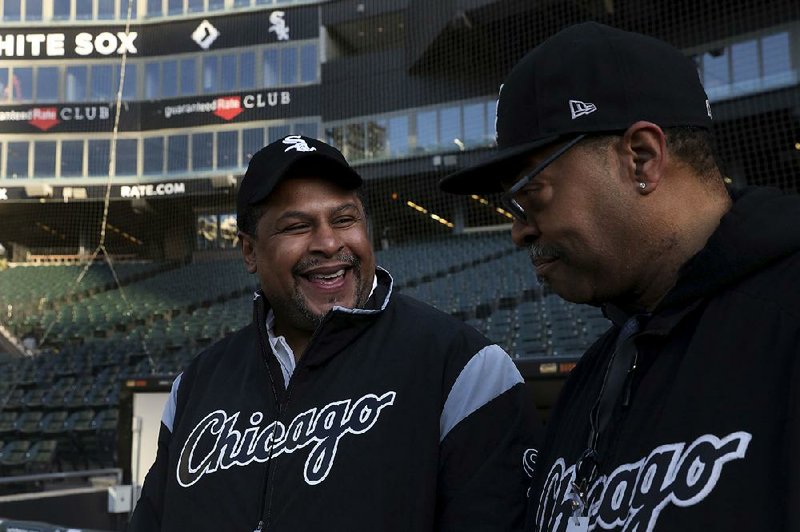 Nevest Coleman, left, smiles as fellow grounds crew and friend Harry Smith Jr. shows off some of the newer features of Guaranteed Rate Field in Chicago, Monday, March 26, 2018. The Chicago Tribune reports that DNA evidence led prosecutors last year to vacate the conviction of 49-year-old Nevest Coleman. He'd been convicted in a 1994 rape and murder. He was released from prison in November and declared innocent last month. (Nancy Stone/Chicago Tribune via AP)