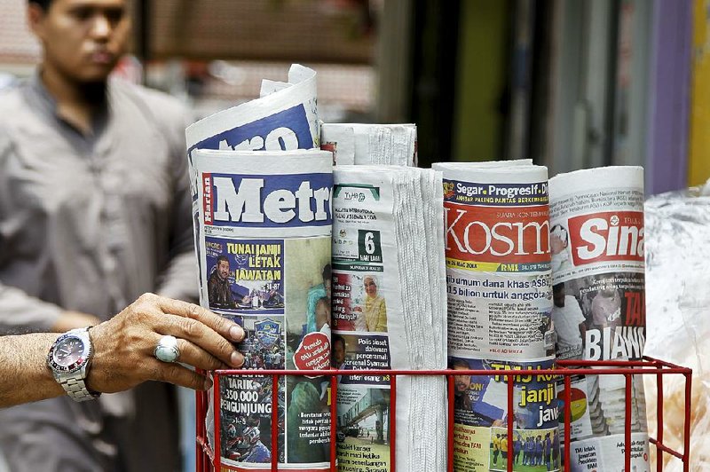 A man selects a newspaper from a shop in Shah Alam, Malaysia, on Monday. Malaysia’s government has proposed legislation to harshly punish the purveyors of fake news.  