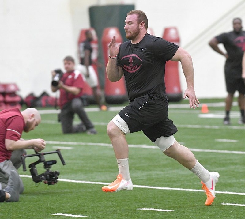Frank Ragnow runs for scouts and coaches during Arkansas’ Pro Day on March 26 in Fayetteville. 