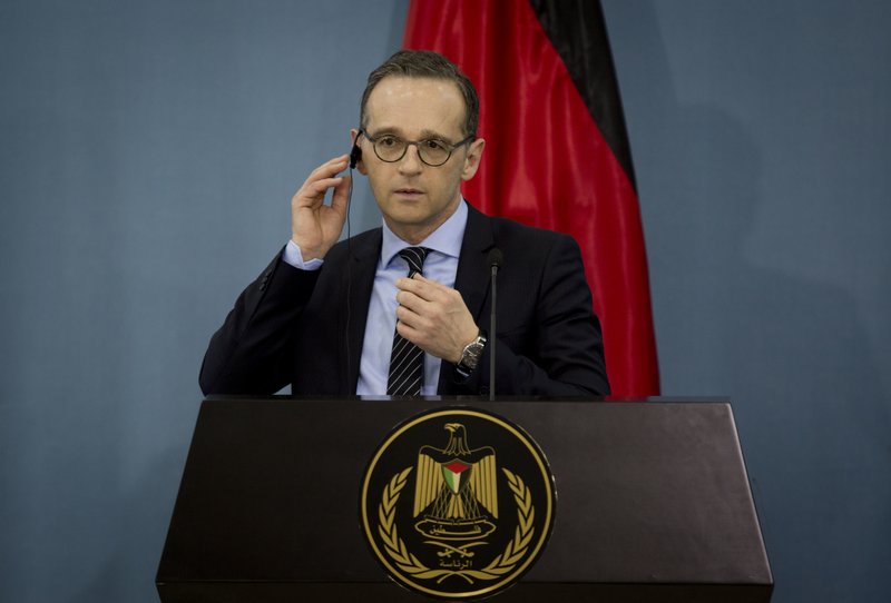 German Foreign Minister Heiko Maas adjusts earpiece during a press conference, in the West Bank city of Ramallah Monday, March 26, 2018. (AP Photo/Majdi Mohammed)