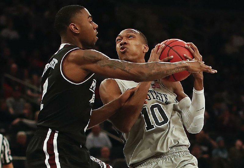 Penn State guard Tony Carr (right) drives to the basket against Mississippi State guard Eli Wright during the Nittany Lions’ 75-60 victory over the Bulldogs on Tuesday in the semifinals of the National Invitational Tournament at Madison Square Garden in New York. Penn State advances to face Utah in Thursday’s championship game.  