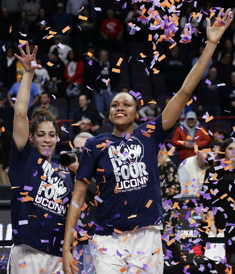 Connecticut’s Kia Nurse (left) and Azura Stevens throw confetti as they celebrate the Huskies’ victory over South Carolina on Monday to advance to the Final Four. Connecticut has dominated women’s basketball so thoroughly the past several seasons that some have questioned whether it’s bad for the sport.  