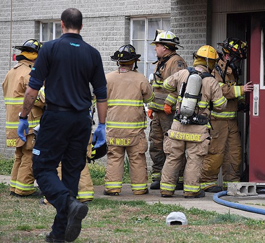 The Sentinel-Record/Grace Brown FATALITY: Hot Springs firefighters conduct a search of an apartment complex on Manor Lane Tuesday evening after one man was killed and several injured.