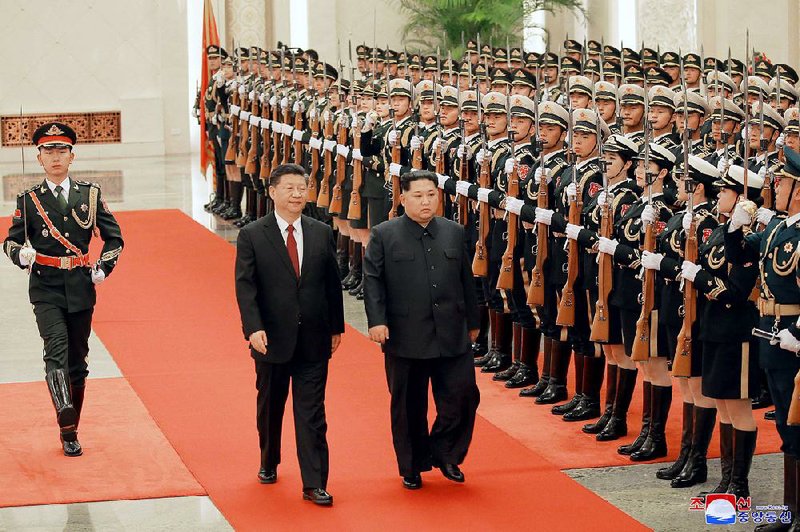 Chinese President Xi Jinping (left) and North Korean leader Kim Jong Un review an honor guard Monday in the Great Hall of the People in Beijing. 