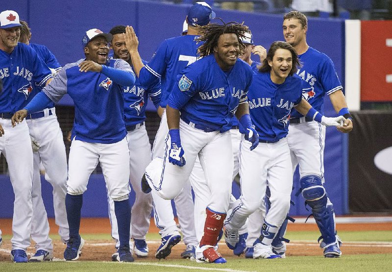Vladimir Guerrero Jr. and his Toronto Blue Jays teammates celebrate his home run against the St. Louis Cardinals during the ninth inning of an exhibition game Tuesday in Montreal.  