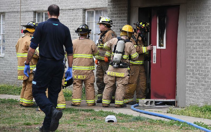 The Sentinel-Record/Grace Brown - Members of the Hot Springs Fire Department enter apartment building 126 at Polo Run Apartments, 230 Manor Circle, after a fire that occured shortly after 5:30 p.m. and left one man dead. 