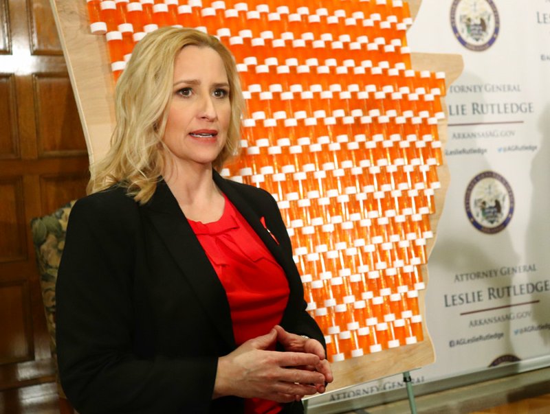 In front of a backdrop that included 401 pill bottles affixed to a wooden map of Arkansas, state Attorney General Leslie Rutledge discusses her lawsuit against three drug manufacturers that she says have contributed to an opioid crisis in the state. 