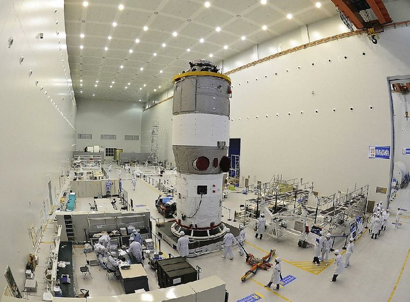 This undated photo shows researchers testing China’s first space station module Tiangong 1 at a launch center in Gansu province, northern China. The module was launched Sept. 29, 2011.