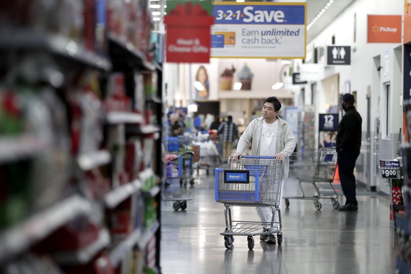 FILE- In this Nov. 9, 2017, file photo, a man pushes a cart while shopping at a Walmart store in North Bergen, N.J. On Thursday, March 29, 2018, the Commerce Department issues its February report on consumer spending. (AP Photo/Julio Cortez, File)