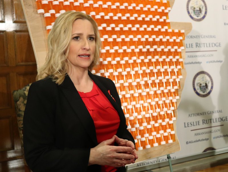 In front of a backdrop that included 401 pill bottles affixed to a wooden map of Arkansas, state Attorney General Leslie Rutledge discusses her lawsuit against three drug manufacturers that she says have contributed to an opioid crisis in the state. ed for 401 deaths two years ago. Rutledge, who appeared with Gov. Asa Hutchinson at a state Capitol news conference on Thursday, March 29, 2018, said drug abuse caused 401 deaths in 2016. (AP Photo/Kelly P. Kissel)