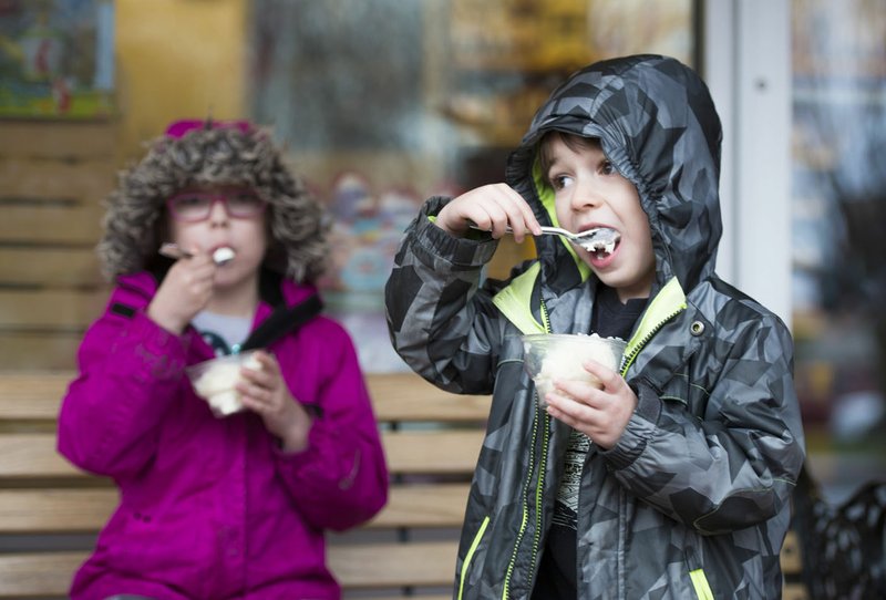 Henry Sosa (from right), 4, and Lucy Sosa, 6, of Kansas City Mo., eat ice cream Thursday at The Walmart Museum at in Bentonville. Yarnell's Ice Cream participated in the centennial celebration of Sam Walton's birthday, providing free butter pecan and homemade vanilla ice cream, courtesy of Walmart. According to the museum, Walton loved butter pecan ice cream. Alice Walton said she has many happy memories of often going for ice cream with her dad, something special the two of them shared.