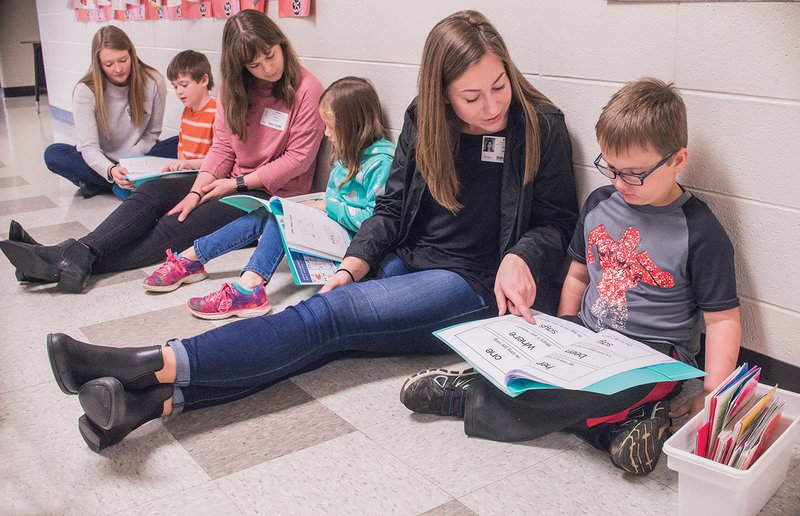 Bison Buddies Katelyn Walker, from left, works with Bentley Robinson, 7; Bryle Alcorn works with Kianna Phanen, 7; and Delaney Bowles works with Xain Jones, also 7. Almost 100 Harding University student-athletes volunteer to help students at Westside Elementary School in Searcy, as well as other schools in the area. The women pictured are members of the golf team.