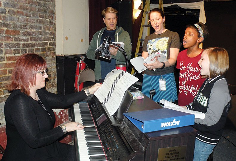 Heidi McCartney, seated, musical director of Chitty Chitty Bang Bang, directs the principal players as they rehearse the song “Teamwork.” The principals are Kevin Crumpler, from left, who plays Caractacus Potts; Paige Carpenter, who plays Truly Scrumptious; and Melody Small and Reagan McCartney, who appear as Potts’ children, Jemima and Jeremy Potts.