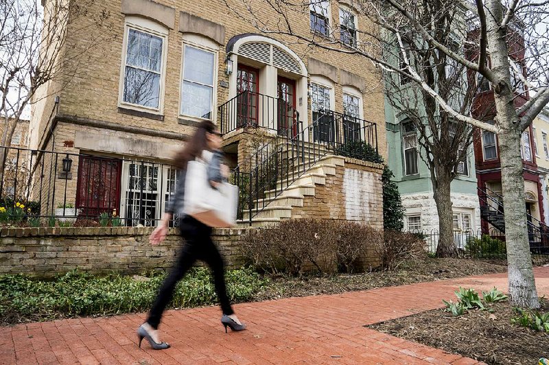 A woman on Friday passes the condo building where Scott Pruitt, Environmental Protection Agency administrator, has stayed in Washington.  