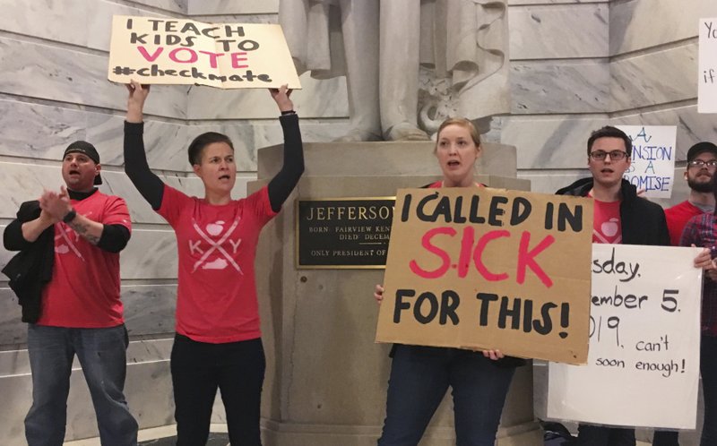 Whitney Walker, second left, and Tracy Kurzendoerfer protest outside of Kentucky Gov. Matt Bevin's office on Friday, March 30, 2018 in Frankfort, Ky. Walker and Kurzendoerfer are teachers in Fayette County. Both called in sick on Friday to protest a bill lawmakers passed late Thursday that makes changes to the state's pension system. The district was one of several forced to close because of the number of teacher absences. (AP Photo/Adam Beam)