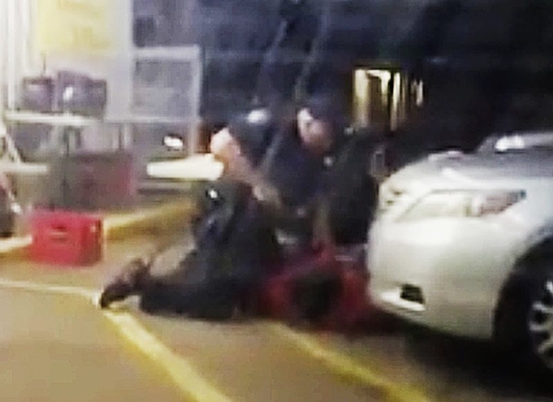 FILE - In this July 5, 2016 image made from video provided by Arthur Reed, Alton Sterling is restrained by two Baton Rouge police officers, one holding a gun, outside a convenience store in Baton Rouge, La. Moments later, one of the officers shot and killed Sterling, a black man who had been selling CDs outside the store, while he was on the ground.  (Arthur Reed via AP, File