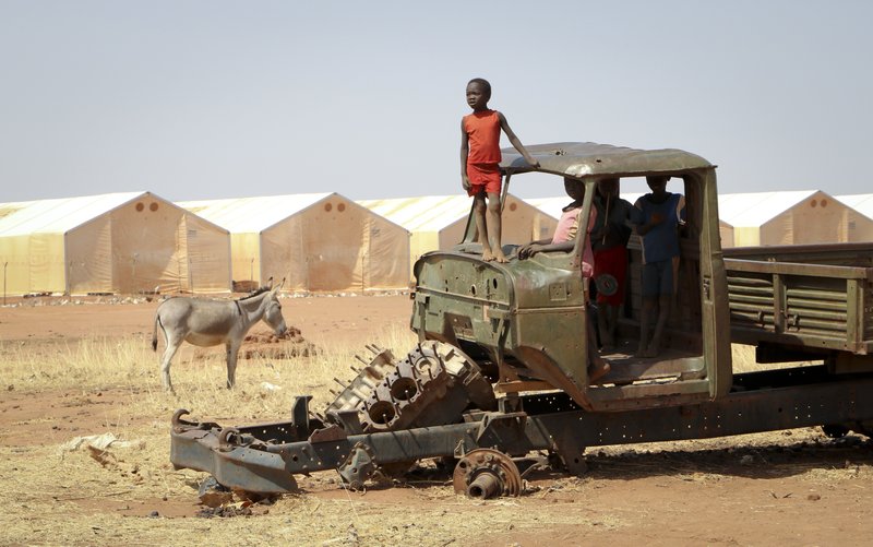 In this Feb. 20, 2018, photo, a Sudanese refugee boy stands on top of a broken-down tractor in Yida, South Sudan. While millions of South Sudanese flee their country in what the United Nations has called the world's fastest-growing refugee crisis since the Rwandan genocide, hundreds of thousands of people from neighboring Sudan have found an unlikely haven there from fighting at home. (AP Photo/Sam Mednick)