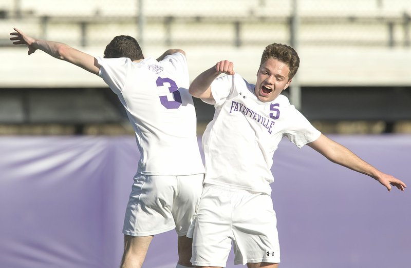 NWA Democrat-Gazette/BEN GOFF @NWABENGOFF Jonah Glover (5) and Charles Henry (3) of Fayetteville celebrate Friday after Glover's goal against Rogers Heritage at Harmon Stadium in Fayetteville.