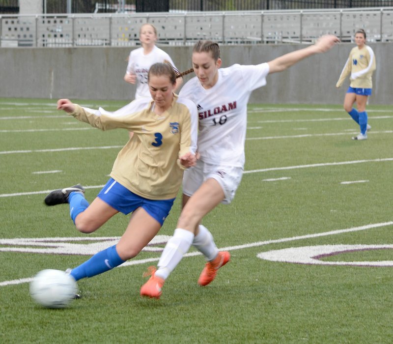 Graham Thomas/Siloam Sunday Harrison defender Katie Fowler, left, tries to shield Siloam Springs sophomore Shelby Johnson from the ball during the first half of Tuesday's 5A/6A District 1 girls soccer match at Panther Stadium. Siloam Springs defeated Harrison 3-1.
