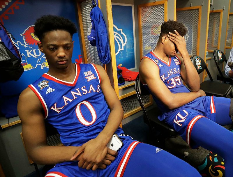 Kansas’ Marcus Garrett (left) and Udoka Azubuike react in the locker room after Saturday’s 95-79 semifinal loss to Villanova. The Lawrence (Kan.) Police Department tried to ease the Jayhawks’ loss with a series of tweets.
