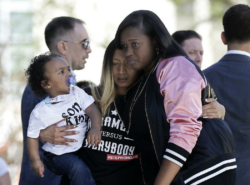 Salena Manni (center), the fiancee of police shooting victim Stephon Clark, holds the couple’s son, Aiden, as she is hugged by Cecilia McClenton at a rally honoring Clark and calling for police changes on Saturday in Sacramento, Calif.
