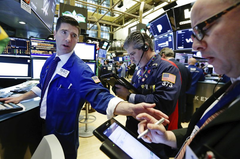 Specialist Thomas McArdle, left, works with traders John Panin, center, and Jeffrey Vazquez on the floor of the New York Stock Exchange, Monday, April 2, 2018. U.S. stocks are skidding Monday morning after China raised import duties on U.S. pork, apples and other products. (AP Photo/Richard Drew)