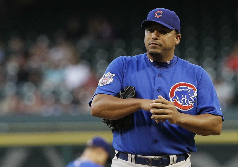 Former Chicago Cubs starting pitcher Carlos Zambrano rubs his hand after trying to make a barehanded catch
in 2010 against the Houston Astros. The sometimes fiery pitcher is now a minister.