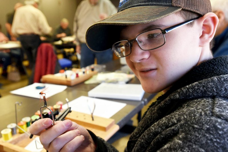 Tristan Avila, 15, the youngest student in the Bella Fly Tyers fly-tying class, shows a finished fly he tied. Beginner and advanced classes are offered. Tyers in the beginner class complete a different fly each class session.