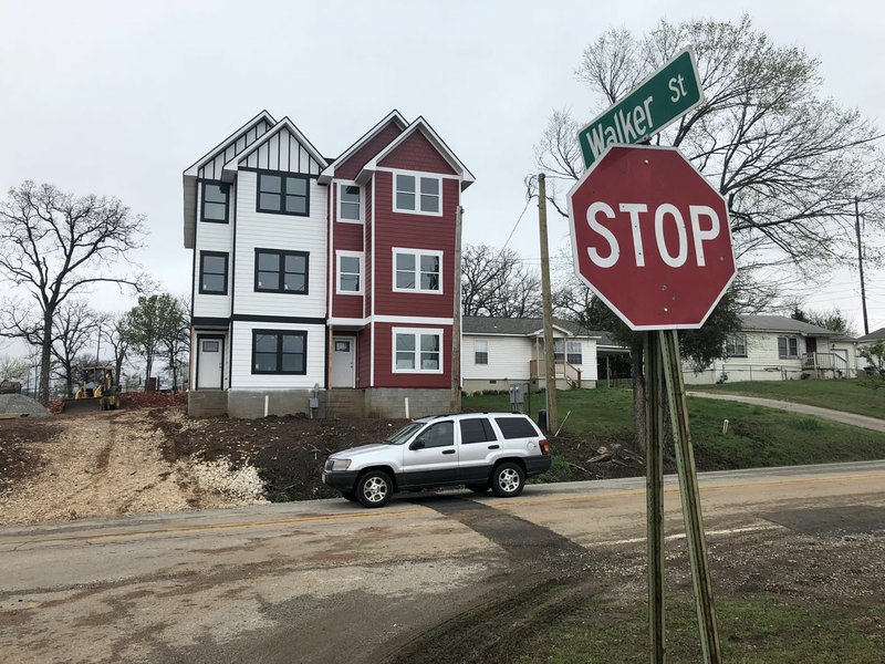 A car is driven down Brooks Avenue near Walker Street in the Parksdale neighborhood of south Fayetteville on Monday. Several neighbors are concerned more townhouses like the one seen at this intersection could eventually replace the single-family homes of the neighborhood.