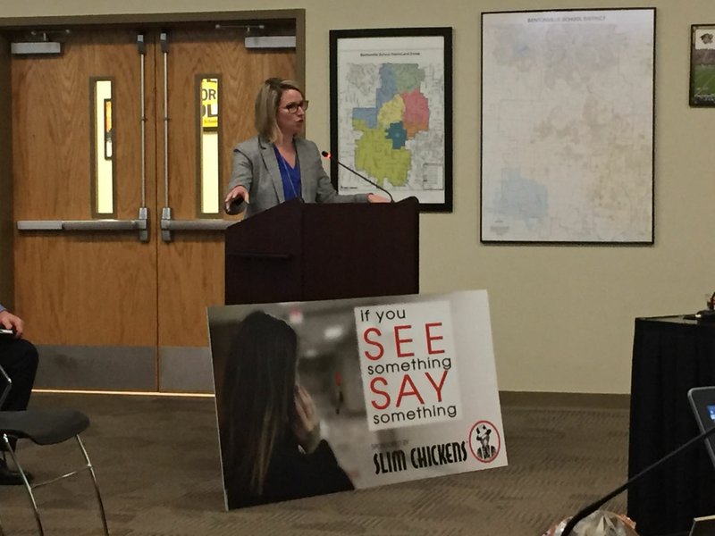 Janet Schwanhausser, finance director for the Bentonville School District, presents information on school bus advertising at the Bentonville School Board's meeting on Monday, April 2, 2018. In front of her is a mock-up of the type of sign that could appear soon on Bentonville buses.