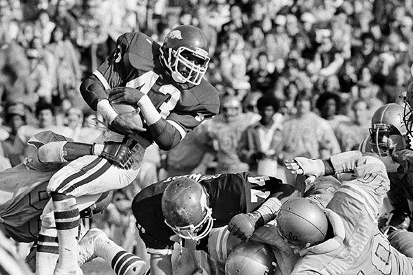 Arkansas' fullback Jerry Eckwood (43) looks down field for more yardage as UCLA's left tackle Billy Don Jackson holds on for the tackle during first half action in the Fiesta Bowl in Tempe, Ariz., Dec. 26, 1978. Arkansas' right guard (74) George Stewart tries to open the hole further. UCLA and Arkansas played to a 10-10 tie. (AP Photo/Lennox McLendon)

