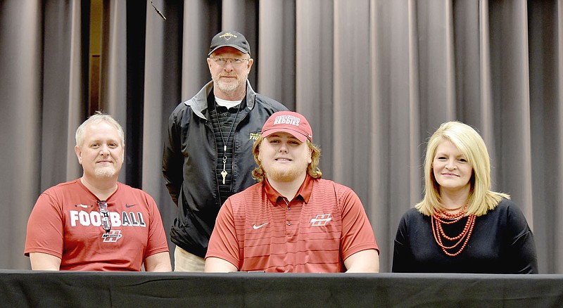 Shelley Williams Special to the Enterprise-Leader Prairie Grove senior Will Hawkins (center), flanked by his parents Jeff and Beth Hawkins, of Prairie Grove, signed a national letter of intent to play college football for Henderson State, of Arkadelphia, on Wednesday, Feb. 7. Will demonstrated his versatility by playing both center and tackle on the offensive line as well as defensive tackle helping Prairie Grove reach the state 4A quarterfinals for the third straight year in 2017.