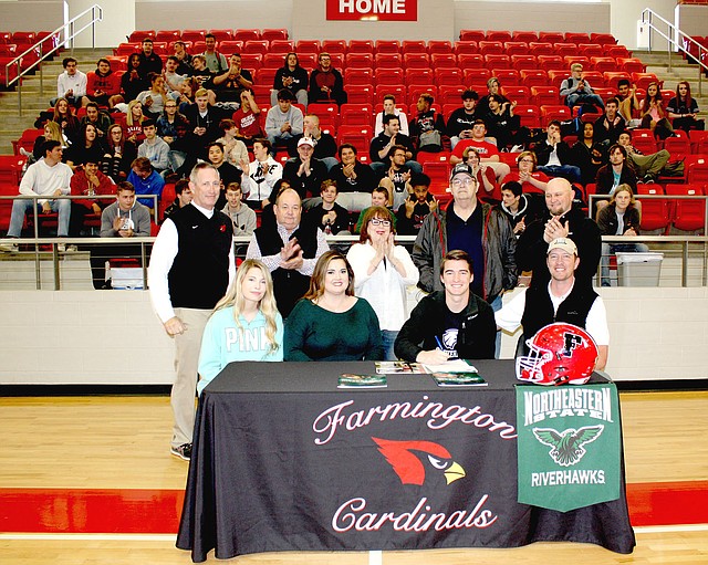 MARK HUMPHREY ENTERPRISE-LEADER Farmington senior Trey Waggle, seated with his parents, Josh and Kelley Waggle, and sister Paige Waggle, a Farmington freshman, signed a National letter of intent to play college football as a deep-snapper for Northeastern University of Tahlequah, Okla., on Wednesday, March 7, at Cardinal Arena. Witnessing the occasion were (standing from left): Farmington football coach Mike Adams, Farmington Mayor Ernie Penn, Trey's maternal grandparents Debra and Brad Rice, and long-time family friend Sam Sparkman.