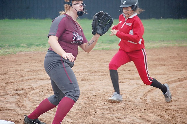 Graham Thomas/Herald-Leader Siloam Springs third baseman Ericka Galloway, left, anticipates the throw to third base during the first inning of Monday's 5A/6A District 1 softball game against Russellville. The Lady Cyclones defeated the Lady Panthers 18-3.