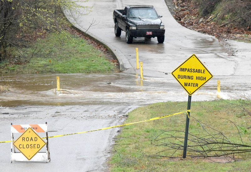 A pickup truck waits at the base of Grant Avenue in Decatur March 27 as flood waters closed the low-water bridge across Columbia Hollow Creek. Residents of Grant Springs Apartments were stranded for much of the day until the flood water receded enough that they could cross the bridge.