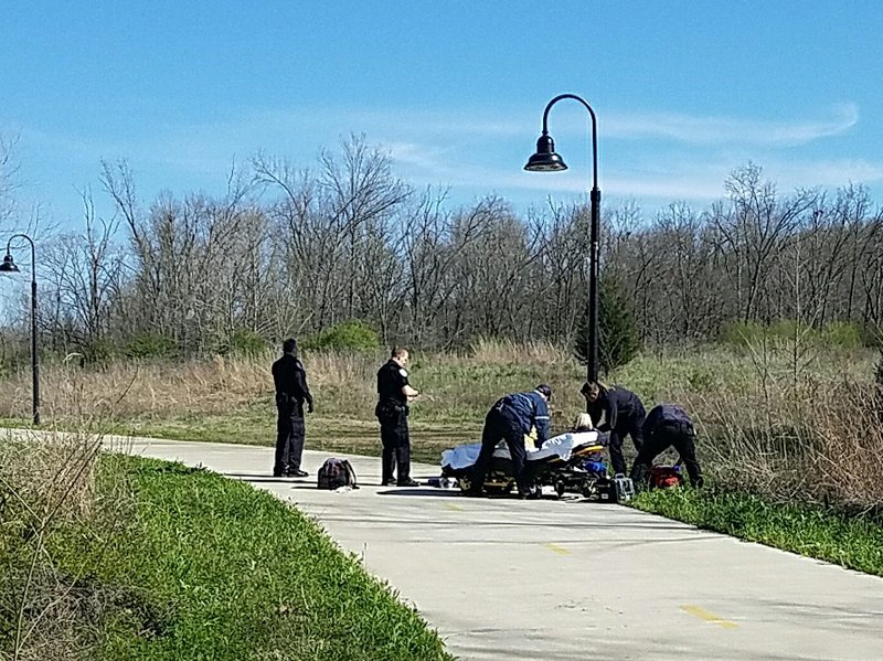 NWA Democrat-Gazette/Ashton Eley
Paramedics help a woman who harmed herself Wednesday April 4, 2018 along the Town Branch Trail in Fayetteville. 